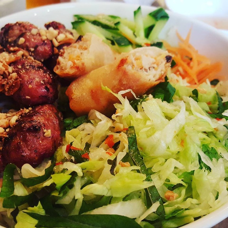 Noodle salad with pork and prawn spring rolls