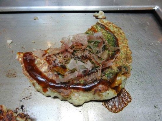 Okonomiyaki cooking on the hotplate (with a piece out of it!)